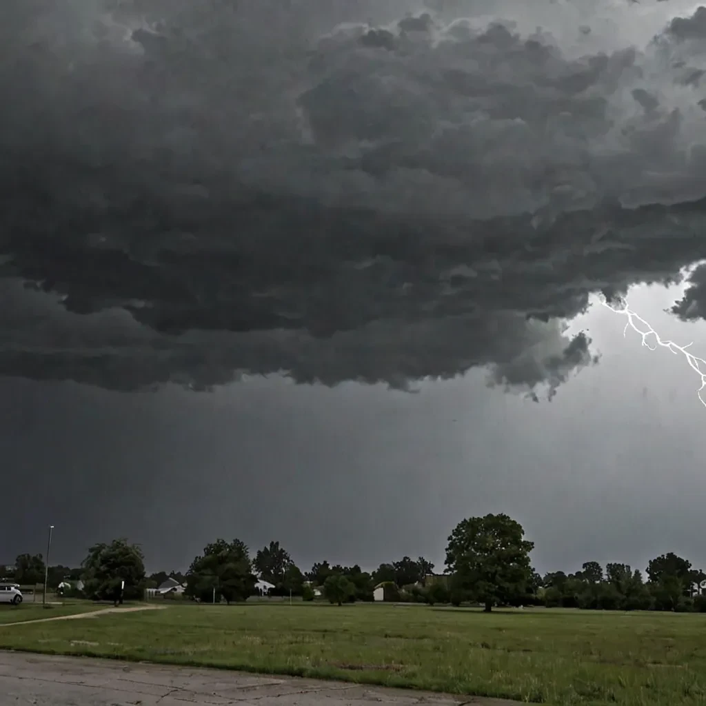 Dark, heavy clouds hanging low in the sky, with visible rain falling from them.