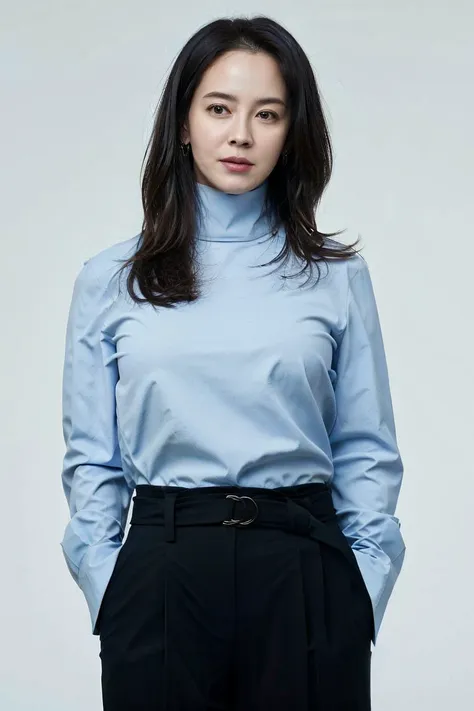 a woman in a blue shirt and black pants posing for a picture with her hands on her hips and her hands on her hips