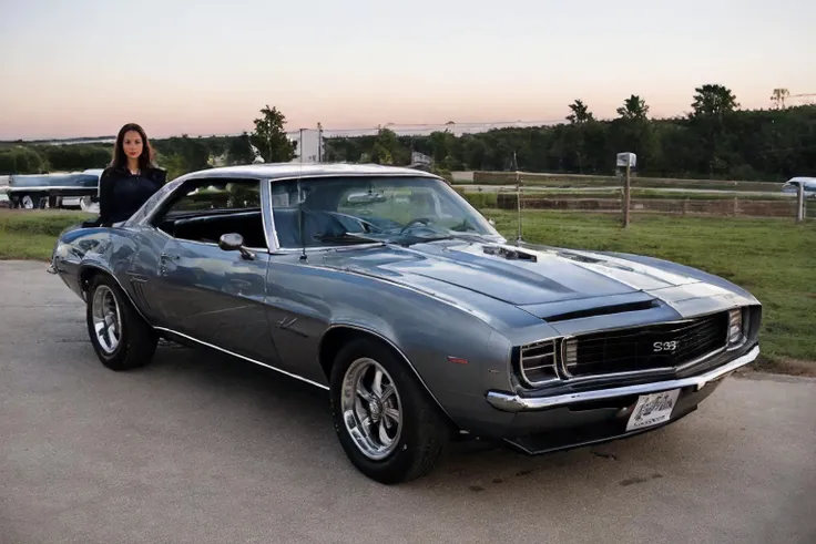 <lora:DianeWebber:0.85>, realstic photo of dianewebber, a woman standing next to a <lora:60s_Camaro:0.8> silver camaro, simple background, (masterpiece:1.0), (best quality:1.0), beautiful, (intricate details), unity 8k wallpaper, ultra detailed