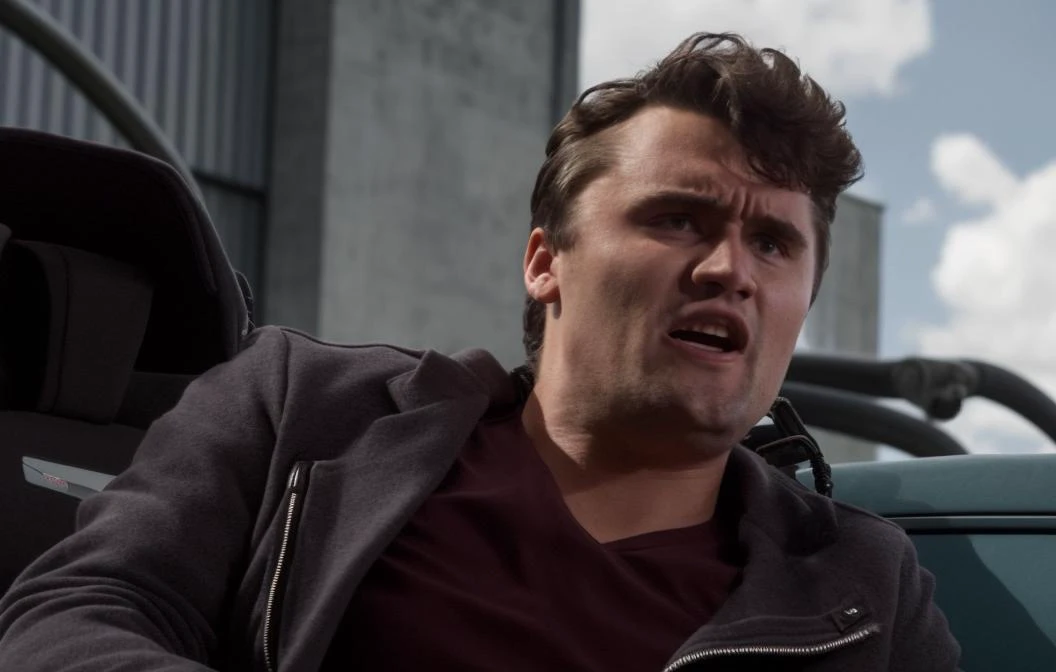 In a desolate post-apocalyptic world, charliekirk person traverses through an abandoned mall and theme park. The soundtrack is heavily layered with Nine Inch Nails music, setting the stage for an impending epic climax. As the camera draws closer to (the character:1.39), it becomes apparent that they are tethered to a computer that provides access to a braintrance internet, causing the system to shatter the glass from within. The motherboard generates amusement in the form of photorealistic images of charliekirk person bellowing in rage. The setting has a photorealistic appearance reminiscent of a David Fincher film, featuring light reflections and an industrial atmosphere. The footage includes glimpses of coding hackers and magic phreaking, but the content has been censored for MTV. The scene includes a sci-fi space capsule, the phantom zone, and sequences that are notably absent from the video. The wires and cords connecting to the medical equipment that the cyborg doctor utilizes discharge electrical charges and sparkles. The scene also features medical devices such as an MRI, X-ray, and PET scan, and a pregnant individual is present. While