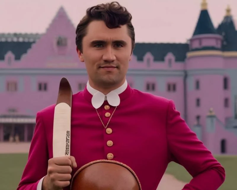 charliekirk person is wearing a sombrero de charro holding golf, screenshot from The Grand Budapest Hotel (2005)