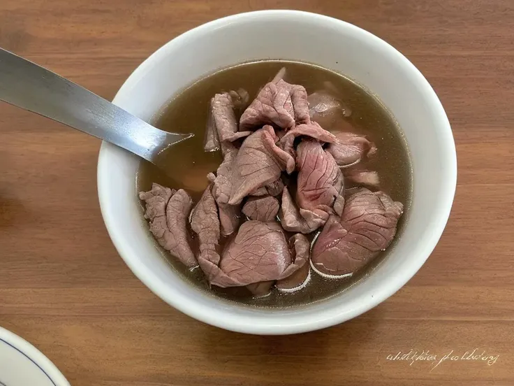 A high-resolution, hyper-realistic image of a bowl of Sweetbeefsoup. This traditional dish features a clear, sweet broth that is the star of the dish. The broth is simmered to perfection, with a hint of sweetness that tantalizes the taste buds. A subtle hint of pink is added to the broth, giving it a unique and appealing look. The soup is garnished with fresh ginger and scallions, which are evenly sprinkled throughout the broth, adding a pop of color and enhancing the flavor. It's served in a traditional ceramic bowl, placed on a rustic wooden table. The scene is set in a cozy kitchen, with all elements in sharp focus, creating a clear and detailed image. The lighting should be warm and inviting, highlighting the appetizing qualities of the Sweetbeefsoup and the homely atmosphere of the setting,<lora:beefsoup:0.75>