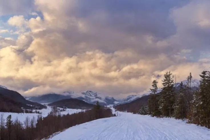 (a large body of water with snowy mountains in the background), (fog, foggy, rolling fog), (clouds, cloudy, rolling clouds), dramatic sky and landscape, extraordinary landscape, (beautiful snow capped mountain background), (forest, dirt path)