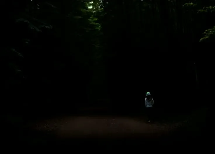 woman walking in the forest at day with a thick canopy overhead