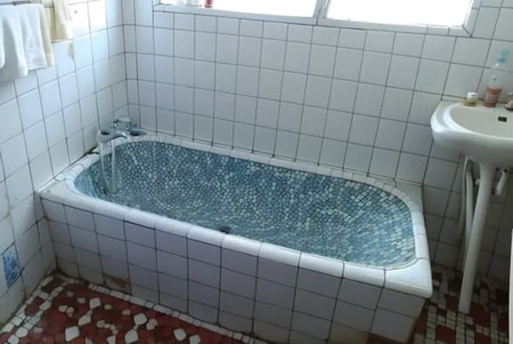 masterpiece, high quality, a bathroom with a mirror and a bathtub in it's corner, and a glass shower door , ,8k uhd, dslr, soft lighting, high quality, film grain, Fujifilm XT3 <lora:100_Taiwan old bathtub_1v5_768_0001BD5e_NR128NA128off:0.8> tile floor, bathroom tiles, tidy ,Taiwan old bathtub, with a blue and white tile, bathtub_\(Taiwan\)