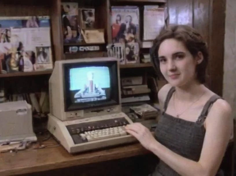 VHSfootage, Winona Person playing with a (Commodore 64:1.5), lit (menorah:1.7) in the background, smiling, holding keyboard, shag carpet, Commodore monitor, wood paneling <lora:VHSfootage:0.9> <lora:Winona Ryder (90s) SDXL - Trigger is Winona Person :0.9>