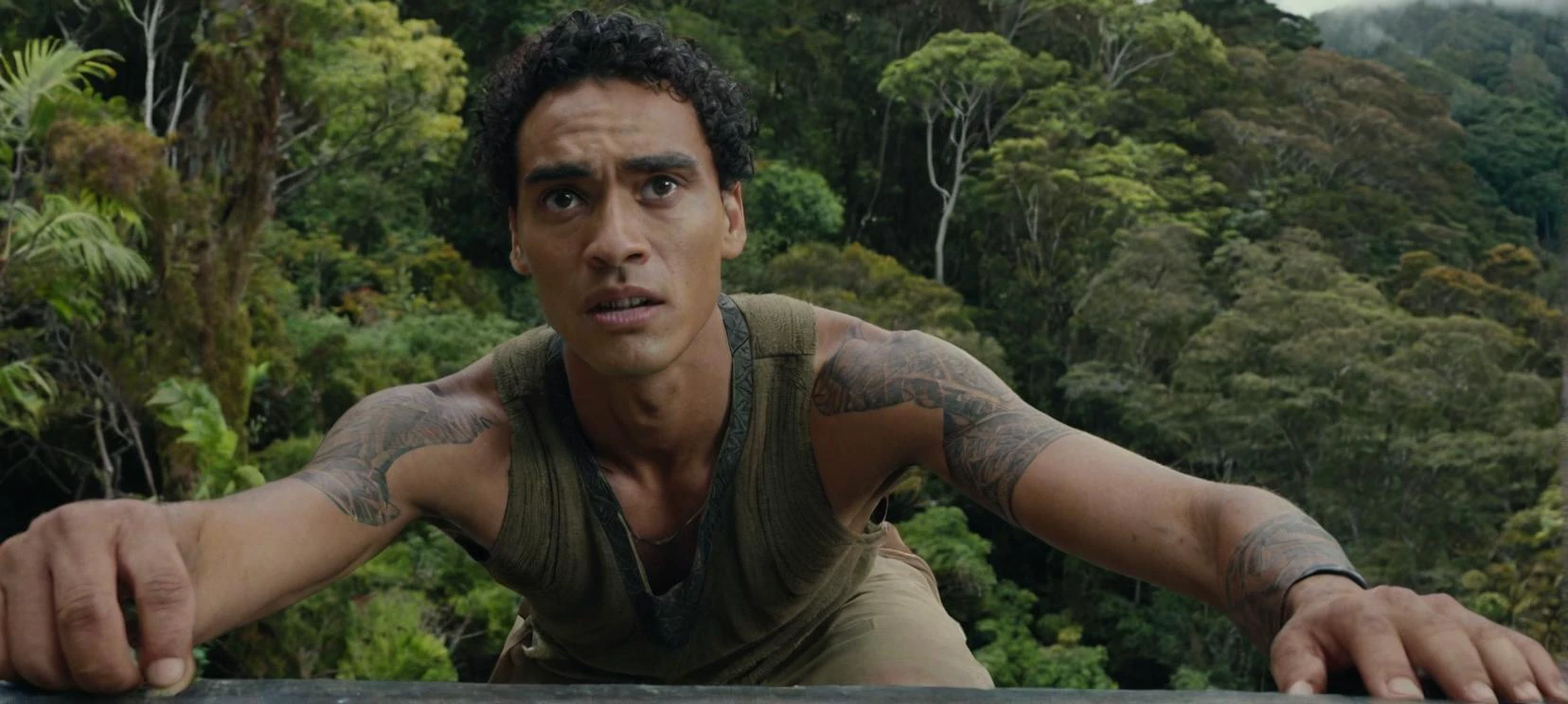 A film still
a selfie of a tall, young, skinny half-maori man up on a ledge in a new zealand forest, with a look of slight concern on his face.
cinematic, movie still