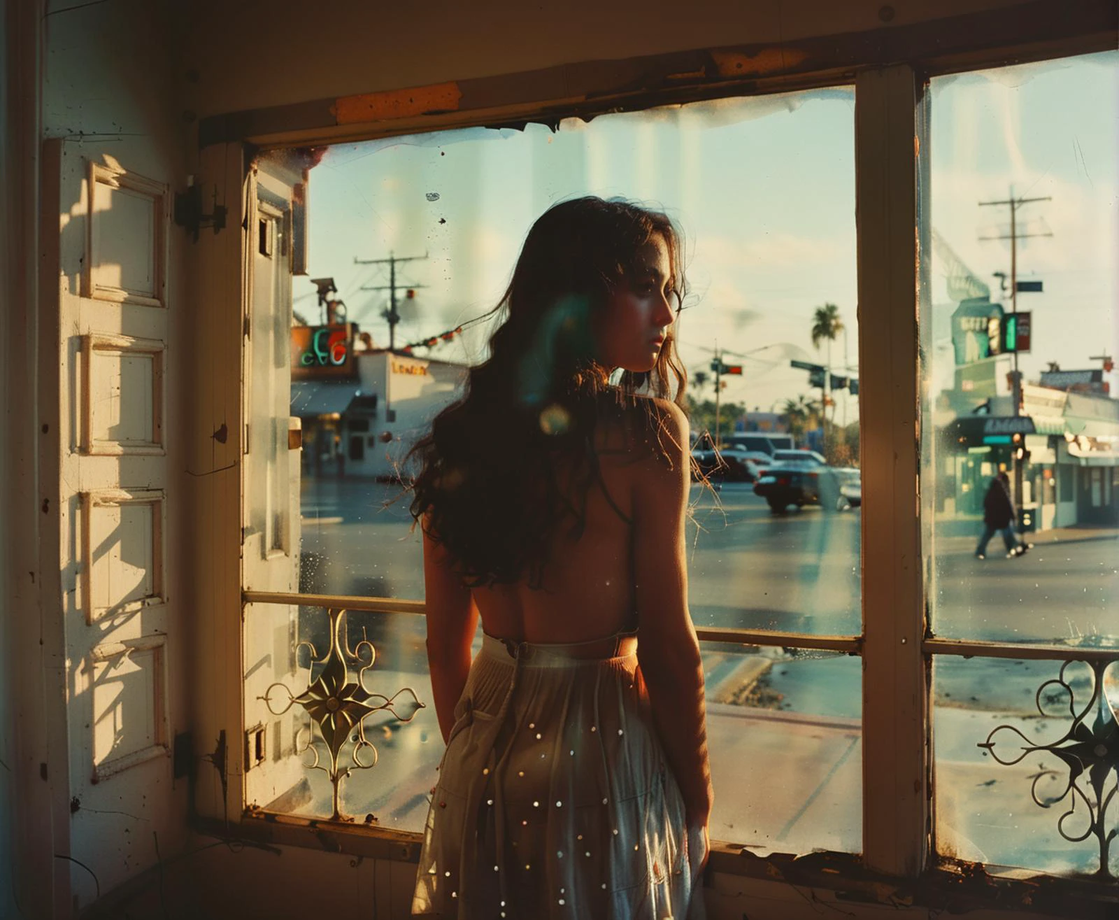 a girl, blue long hair, latina, Standing in the threshold of an ornate door frame silhouette outlined against the soft indoor light hands positioned above head in a pose of invitation, (<lora:FILM_PHOTOGRAPHY_STYLE:1> film photography style, heavy grain), vignette , At Sunset, orange light, setting sun, deep shadows, dramatic sky, serene atmosphere, <lora:sd_xl_dpo_turbo_lora_v1-128dim:0.7>, <lora:tbh156-sdxl:1> style of Philip Lorca diCorcia
