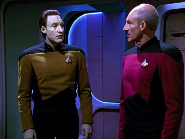 Star Trek TNG, TV Still, Data, frowning and unhappy, wearing a yellow starfleet uniform, talking to Picard, Picard is wearing a red starfleet uniform, they are both standing in medical, full body, facing camera, <lora:StarTrekTNG-v7:1>