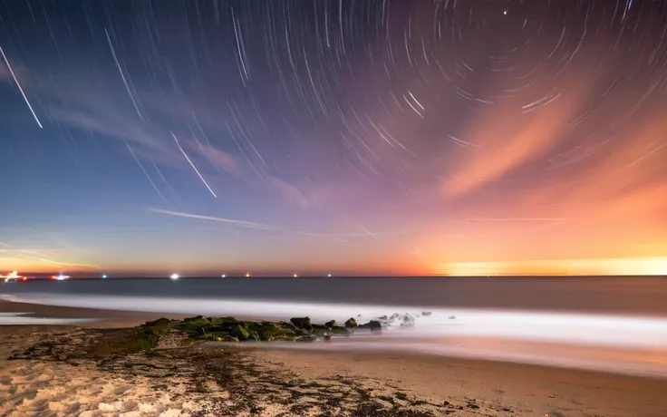 a long exposure of the night sky over the beach