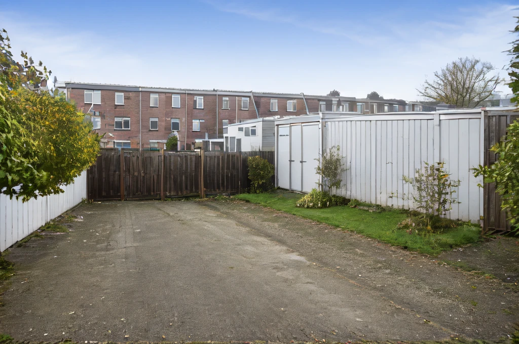 a car park behind a row of houses with fences and sheds, high res<lora:Grienden_Style:0.7>
