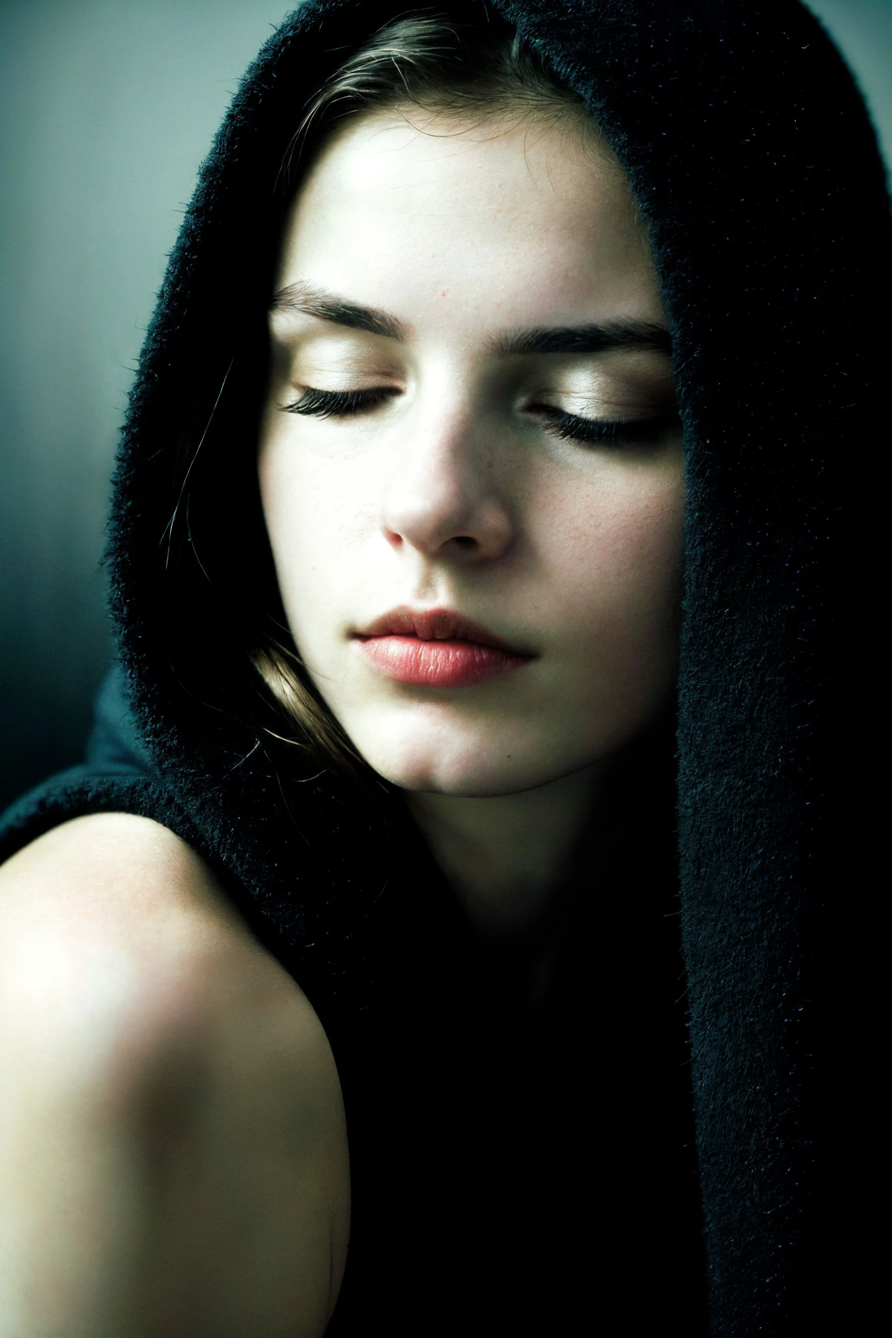 analog photo,silhouette,spotlight,close up portrait,
a beautiful cute petite young european woman,pale skin,highly detailed face,eyes closed,sad facial expression,looking down,
seducing facial expression,wearing a black mantle and a black hood,
RAW candid cinema,16mm,color graded portra 400 film,remarkable color,ultra realistic,
sad admosphere,dark lighting,oppressive atmosphere,depressive colors,