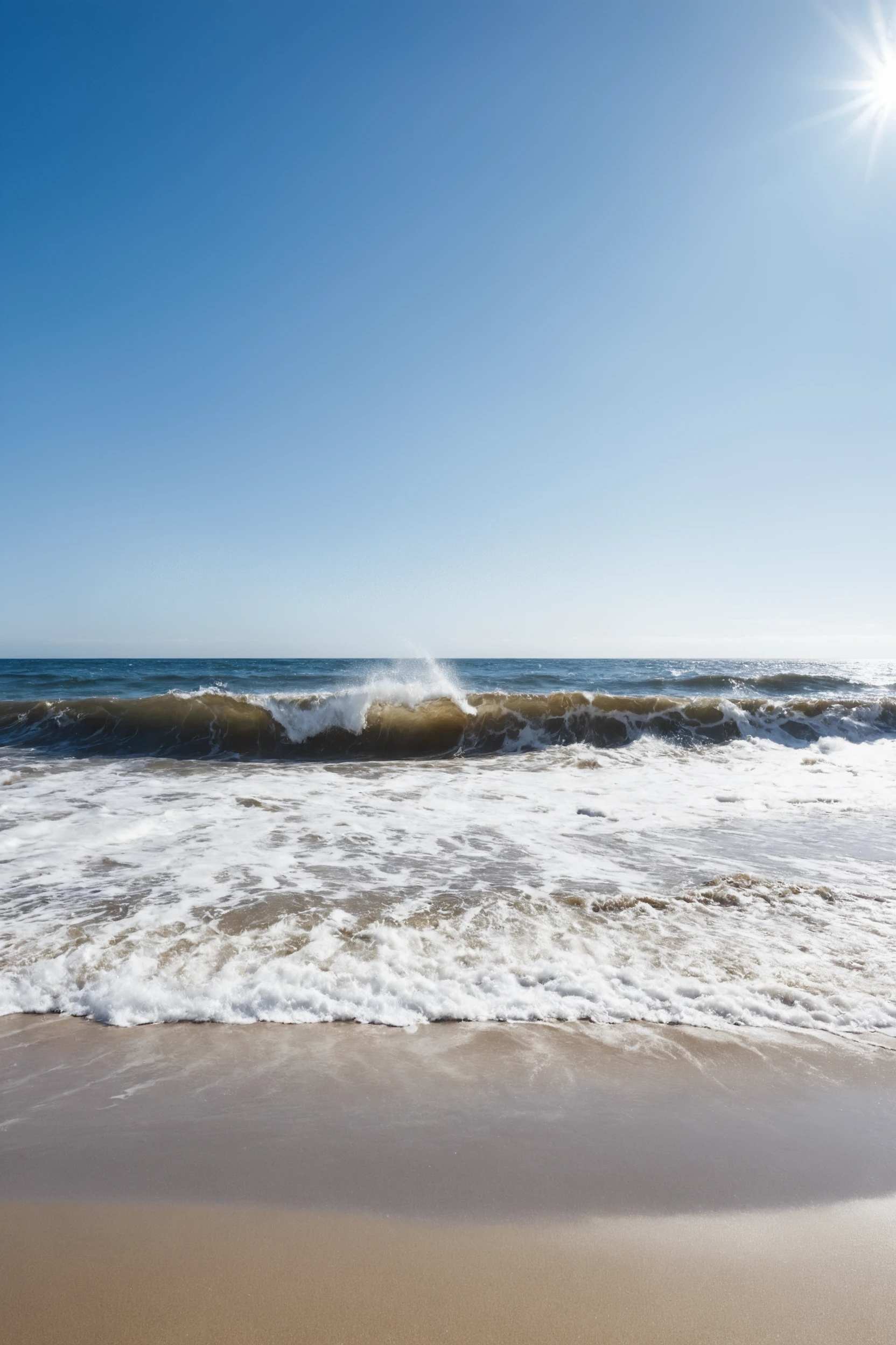 Witness waves crashing on a sandy beach, impeccably photographed under clear blue skies.