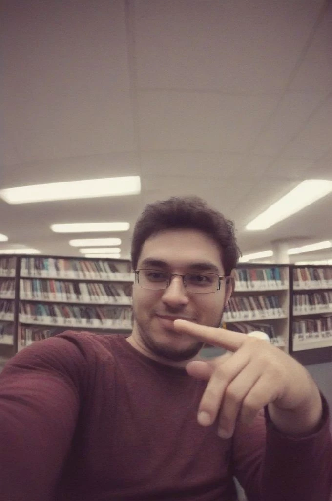 man sitting in library taking a selfie, badquality, low quality <lora:badquality_v02:1>