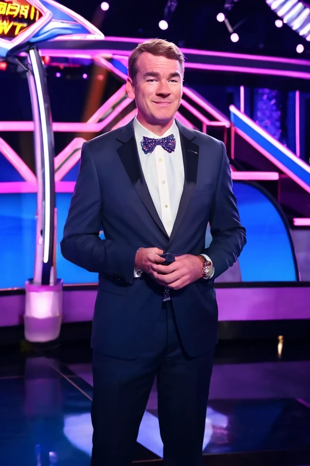 michael bennet <lora:senate_011_michael_bennet:0.65> , face closeup, face focus, shirt, formal, suit, collared shirt, white shirt, jacket,
Dressed in a flashy game show host outfit with a bow tie and sparkly jacket, standing on a game show set, spinning a large prize wheel,
best quality, masterpiece, HDR, professional, studio quality, highres,