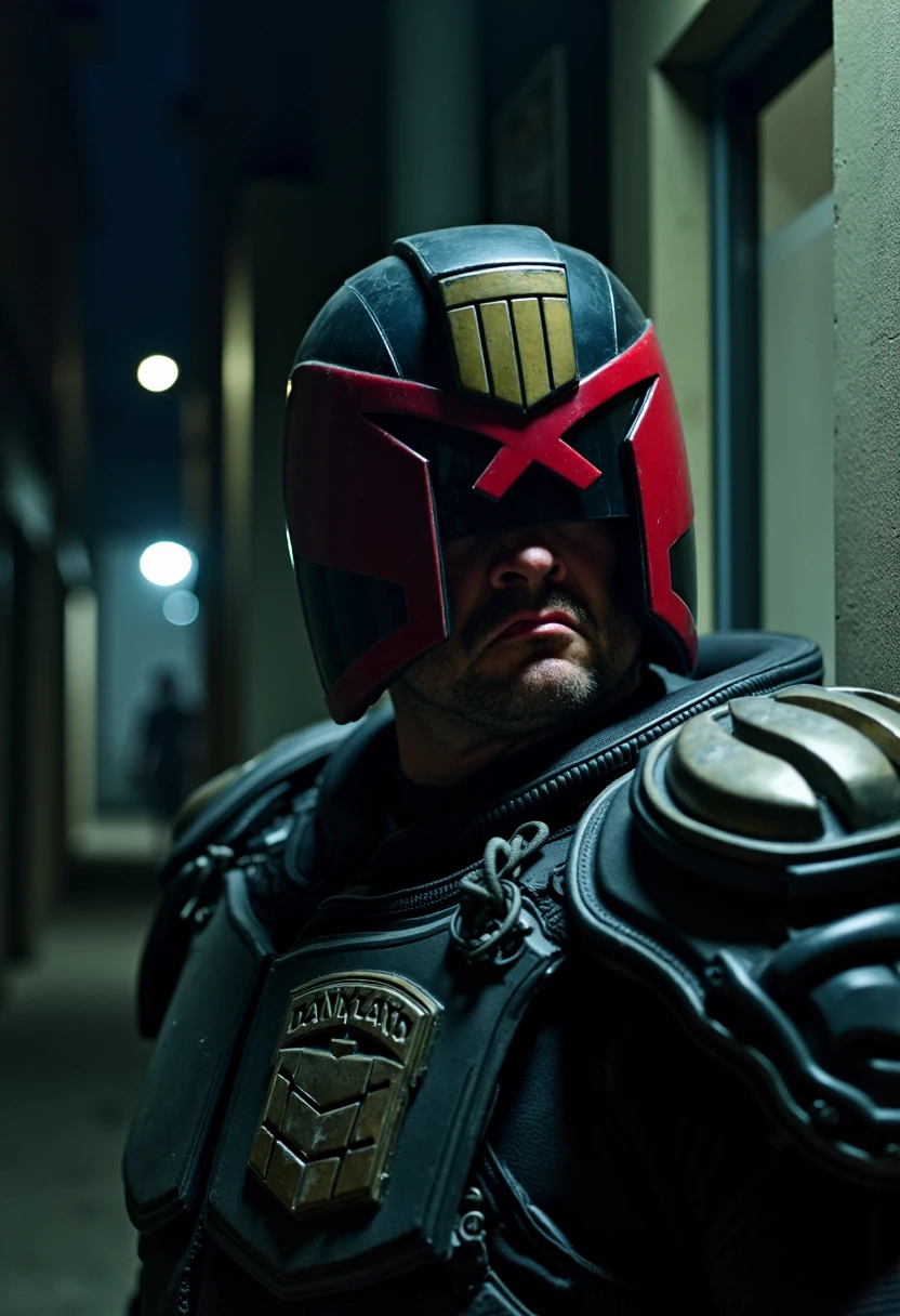 In a dimly lit back alley, Judge Dredd is a towering figure clad in dark, armored gear stands ominously amidst the shadows. The alley, strewn with debris and faintly illuminated by the flickering light of a distant streetlamp, sets a grim stage for the lawman’s presence. His helmet, obscuring all but his stubbled jaw, reflects the sparse light, giving his already intimidating demeanor an edge of cold, unyielding authority. The red visor of his helmet glows faintly, the only hint of the merciless eyes hidden beneath. His lips, set in a stern, unforgiving line, signal the unwavering resolve of a man who knows no fear and delivers justice with absolute certainty.

The photograph captures the scene with a high-contrast, noir-inspired aesthetic, emphasizing the play of light and shadow. The low-key lighting highlights the reflective surfaces of his helmet and armor, creating sharp contrasts against the deep blacks of the alley. The image uses a shallow depth of field, keeping the lawman in sharp focus while the gritty details of the alley blur into the background, enhancing the sense of isolation and tension. The composition is tight, with the figure dominating the frame, his Lawgiver pistol partially visible, hinting at the lethal force he embodies. The overall mood is one of tension and foreboding, with the technical details of the shot amplifying the intimidating presence of the lawman in this urban underworld.