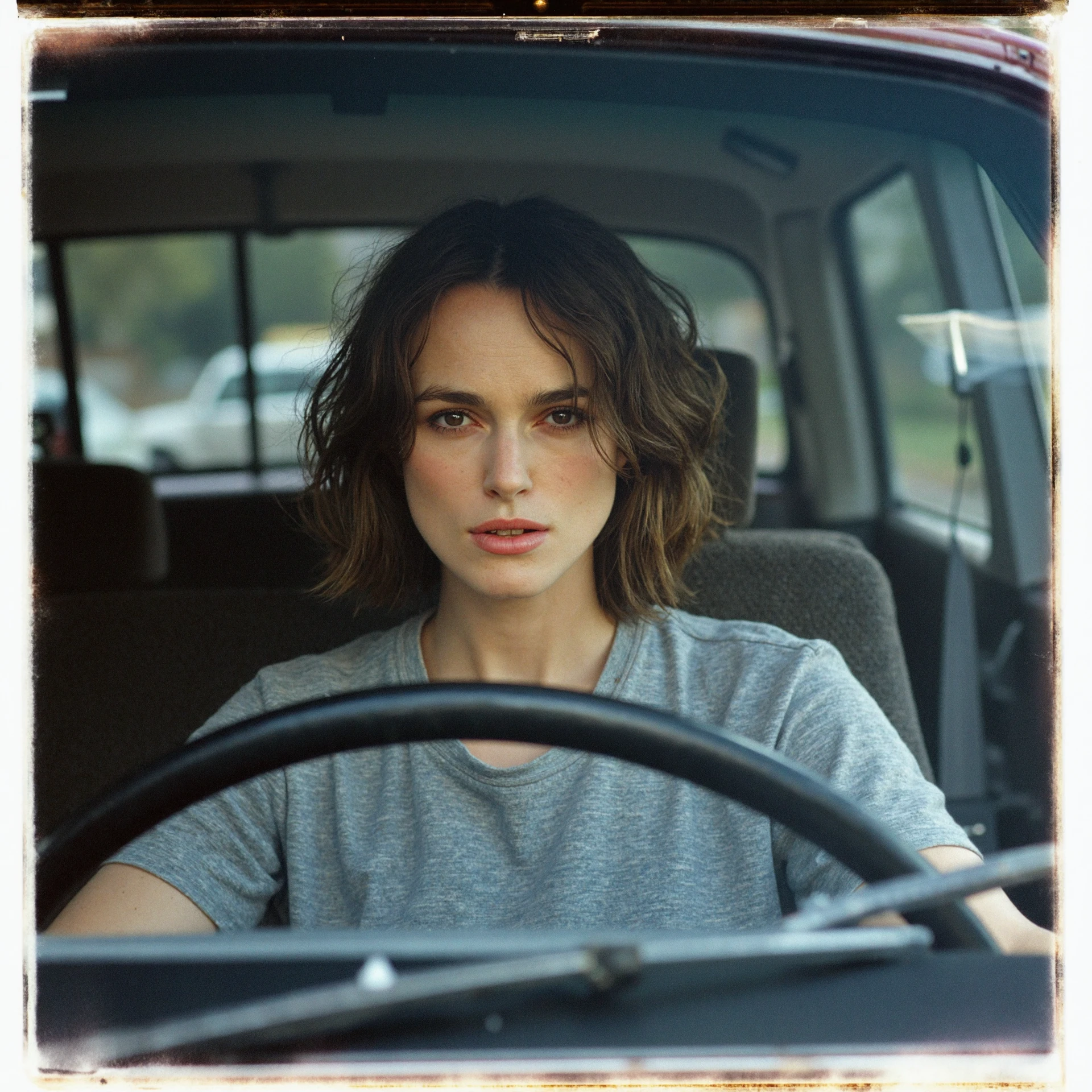 keira knightley has an annoyed look on her face as she is sitting in traffic behind the steering wheel of an old Jeep. She is wearing a grey t-shirt. a captured on a Polaroid PZ 680 <lora:keira_knightley_r8_1600_flux_lora_v1_000002600:1>