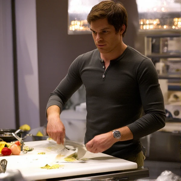 Dexter is cooking in a modern kitchen, using a big knife, looking at the viewer.   <lora:Dexter:0.9>