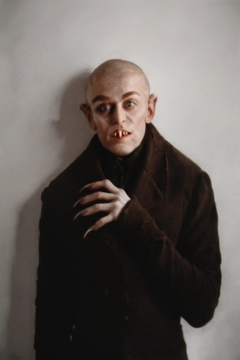 hires digital photo, photorealism, simple white background, upper body, h3rrz0g0rl0k, coat, fangs, bald, head down, looking up at viewer, on hand up, claws <lora:Count_Orlok_PXL-000029:0.8>, intricate details, high resolution,, PonyXL_Scores