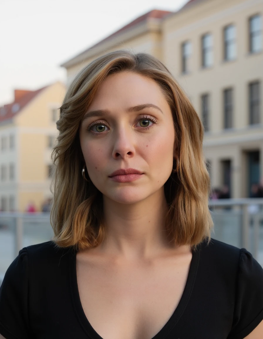 The image is a high-resolution photograph of a person with fair skin and a light complexion. The subject has shoulder-length, straight brown hair that is slightly tousled, framing their face. They are looking directly at the camera with a neutral expression. Their face is adorned with a light dusting of freckles across the cheeks and nose. They are wearing a simple, black, short-sleeved top. Hanging from their earlobe is a pair of long, silver, oval-shaped earrings that dangle slightly, adding a touch of elegance to their appearance.
In the background, the setting appears to be an urban area, possibly a city square or plaza. The backdrop features several buildings with light-colored facades, including one with a reddish-brown roof, and another with a more muted beige color. The buildings have large windows, and there is a hint of a metal fence or railing in the distance, suggesting an open public space. The lighting in the image is natural, indicating it was taken during the day, possibly in the late afternoon or early evening, as the shadows are soft but noticeable. The overall atmosphere is calm and serene, with the subject standing out prominently against the slightly blurred background.,Elizabeth Olsen,<lora:Elizabeth Olsen_Flux_V1:0.92>