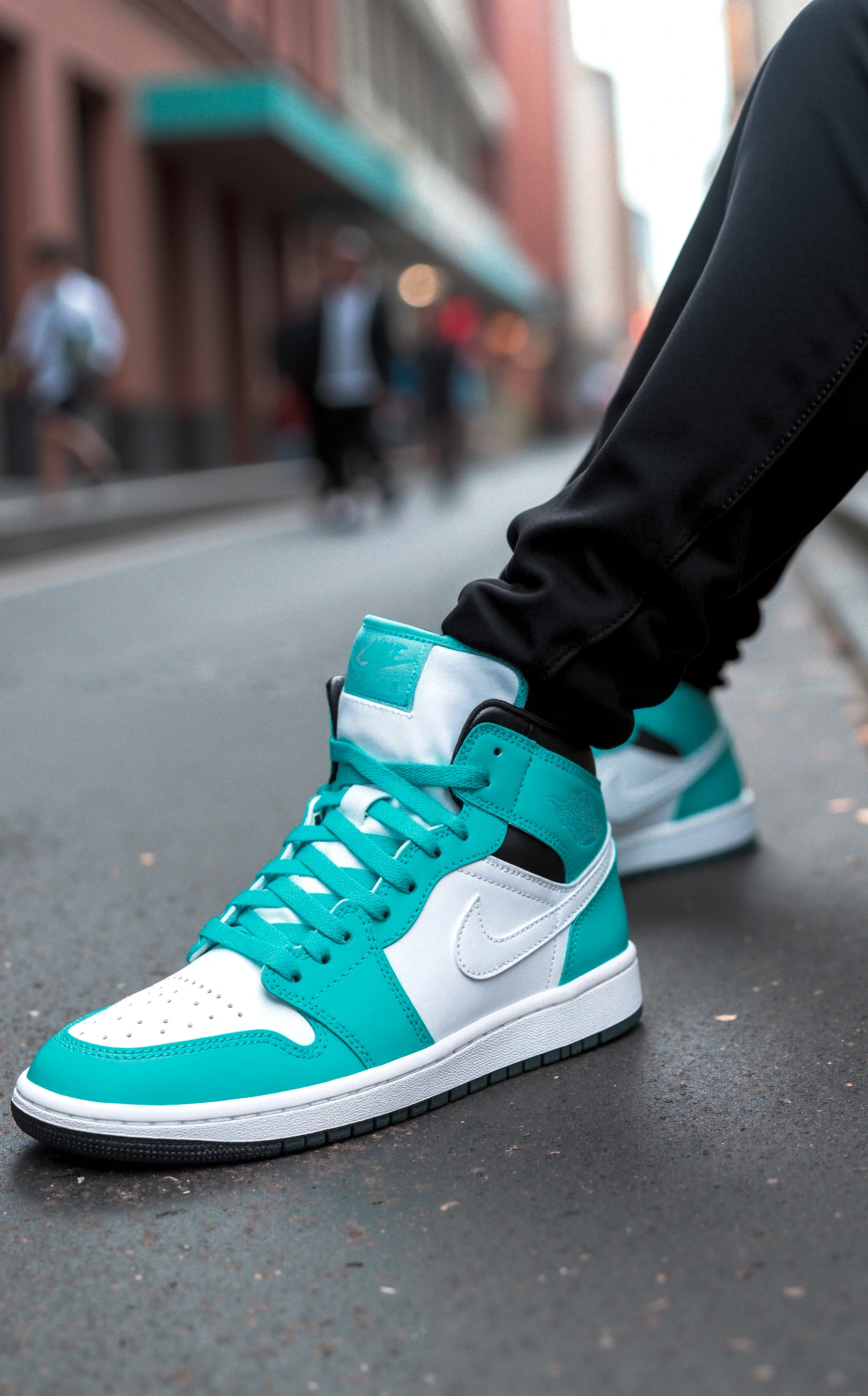 has12345.3f, The image shows a close-up of a pair of vibrant Jordan sneakers worn by someone sitting with their legs crossed. The sneakers are primarily turquoise and white, with a bold, graphic design. The upper is mostly turquoise, with white panels along the side, and a perforated white toe box for breathability. The iconic Nike swoosh is a clean white, matching the laces and tongue of the shoe. A turquoise cushioned collar adds comfort and style to the high-top silhouette. The outsole is black, offering a sharp contrast to the light, airy colors of the shoe’s upper. The overall look of the sneakers is sporty yet stylish, combining elements of classic basketball design with modern streetwear aesthetics. The background features an urban street scene with blurry details of city life, giving the image an energetic, fast-paced feel. The lighting is bright, making the shoes pop, while the city scene in the background stays slightly out of focus, keeping attention on the sneakers.