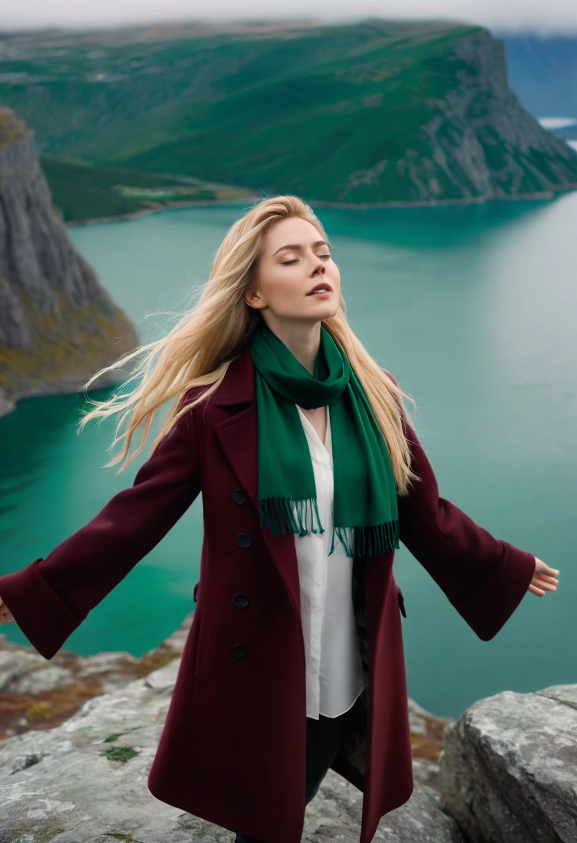 A cinematic shot of a woman renata with long, bright blonde hair standing on a rocky terrain at the edge of a cliff. She is wearing a maroon coat over a white shirt and a emerald scarf. The woman has her eyes closed and her arms outstretched. The background reveals a vast landscape with a body of water and mountains. The sky is overcast.