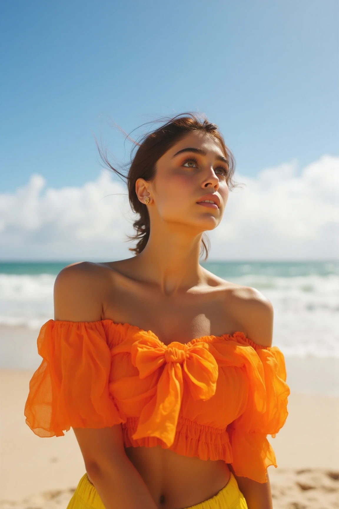 A stunning woman poses elegantly on the sun-kissed beach, her vibrant top billowing gently in the breeze. Framed by the warm tones of Kodak film, her serene features are bathed in soft, golden light. The camera captures a close-up shot of her refined profile, as she gazes out at the breathtaking sky behind her, a canvas of puffy clouds and brilliant blue.