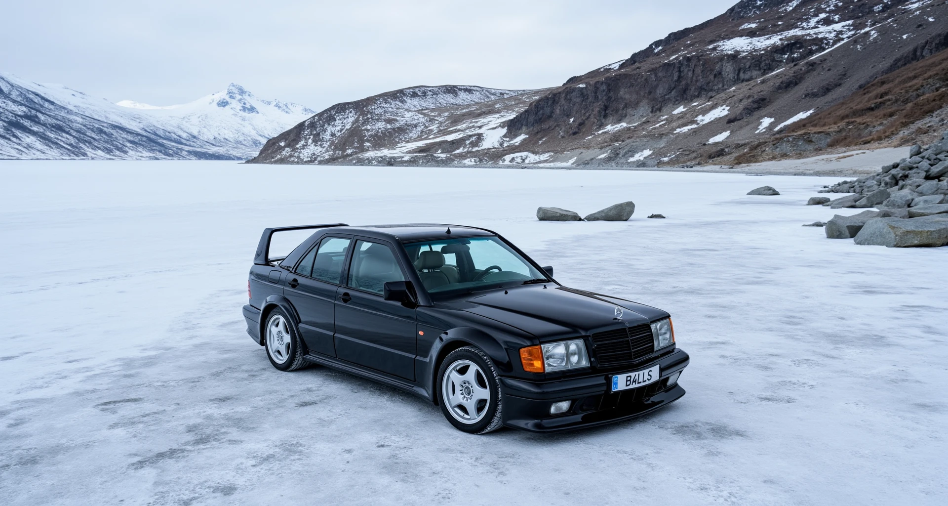 Highres narrow aperture photo shoot of a black mercedes 190e amg evo 2, the quality of the photo is very good and the resolution is 8k, the overall detail of the image is great and athmospheric to a chill car jorney, The registeration plate reads "B4LLS", the aperture is narrow f/9.4, the setting is the top of an rough icy mountain where the beautifull rocks can be seen with a  naked eye, the angle is angled, the lighting of the beach is purely natural, slight film grain, the icy snowing perfectly contrasts the scene, the photo is high resolution 