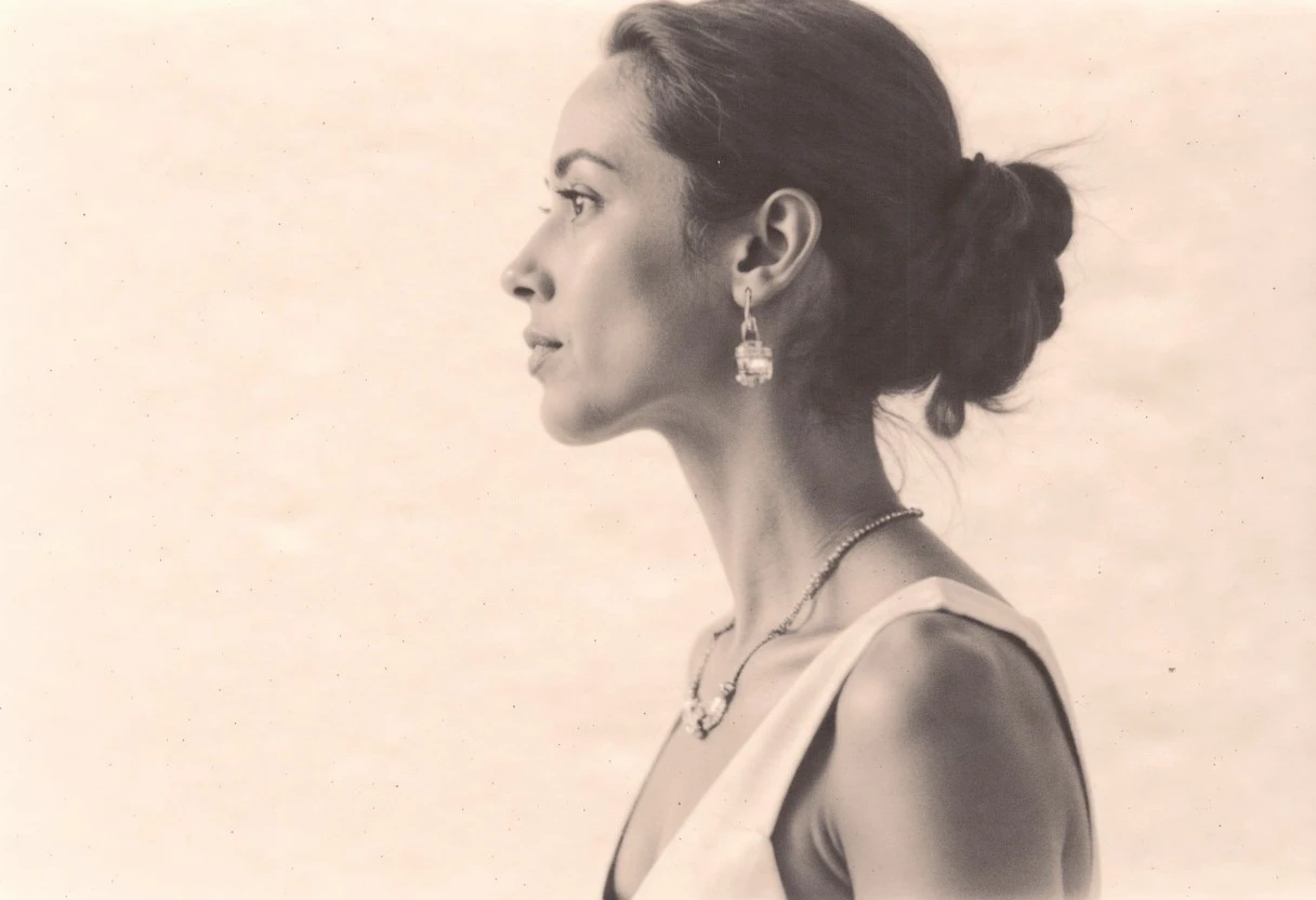 an aesthetic, minimalist depiction of a female profile in side view. The focus is on the soft contours and calm, monochromatic tones. The scene feels mystical and dreamy, almost as if viewed through a delicate mist, with gentle light accentuating the silhouette. The background is diffuse and creamy white, drawing attention to the elegant simplicity of the figure.