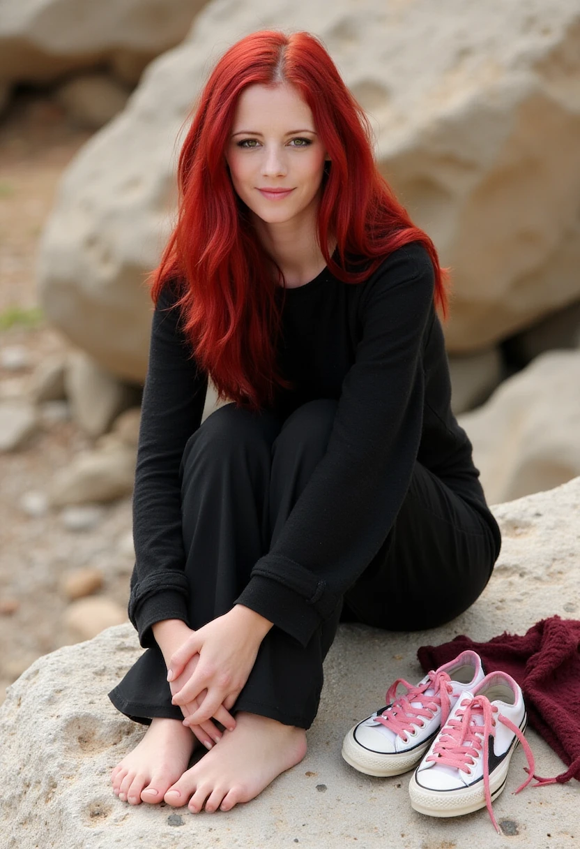 This is a high-resolution photograph featuring a young woman with long, vibrant red hair, seated on a rough, stone surface. She has a light complexion and a slender build. The woman is dressed in a black, long-sleeved sweater and black, loose-fitting pants. She is barefoot, with her feet resting on the stones, and her knees slightly bent. Her expression is neutral, with a slight smile, and she is gazing directly at the camera.

In the background, there is a blurred view of large, weathered rocks, indicating an outdoor setting, possibly a natural or archaeological site. To the left of the woman, there is a pair of worn, white sneakers with pink laces, placed neatly together on the stone surface. A maroon-colored garment, possibly a scarf or a piece of clothing, is casually draped beside the sneakers. The overall scene suggests a tranquil, solitary moment, with the woman appearing relaxed and at ease. The lighting is natural, likely from the sun, and the photograph captures the textures of the stones and the fabric of her clothing vividly. 4R13L