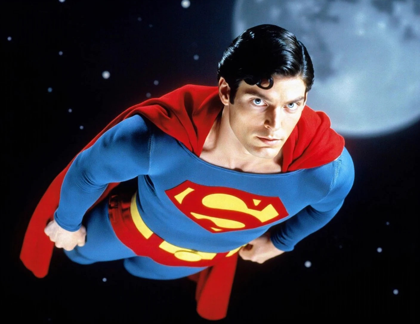 Superman flying through the air against a space background. He is wearing the iconic red and blue suit with the yellow and red "S" logo on the chest, and a red cape billowing behind him. His face is determined and focused, as if he is ready to take on any challenge.