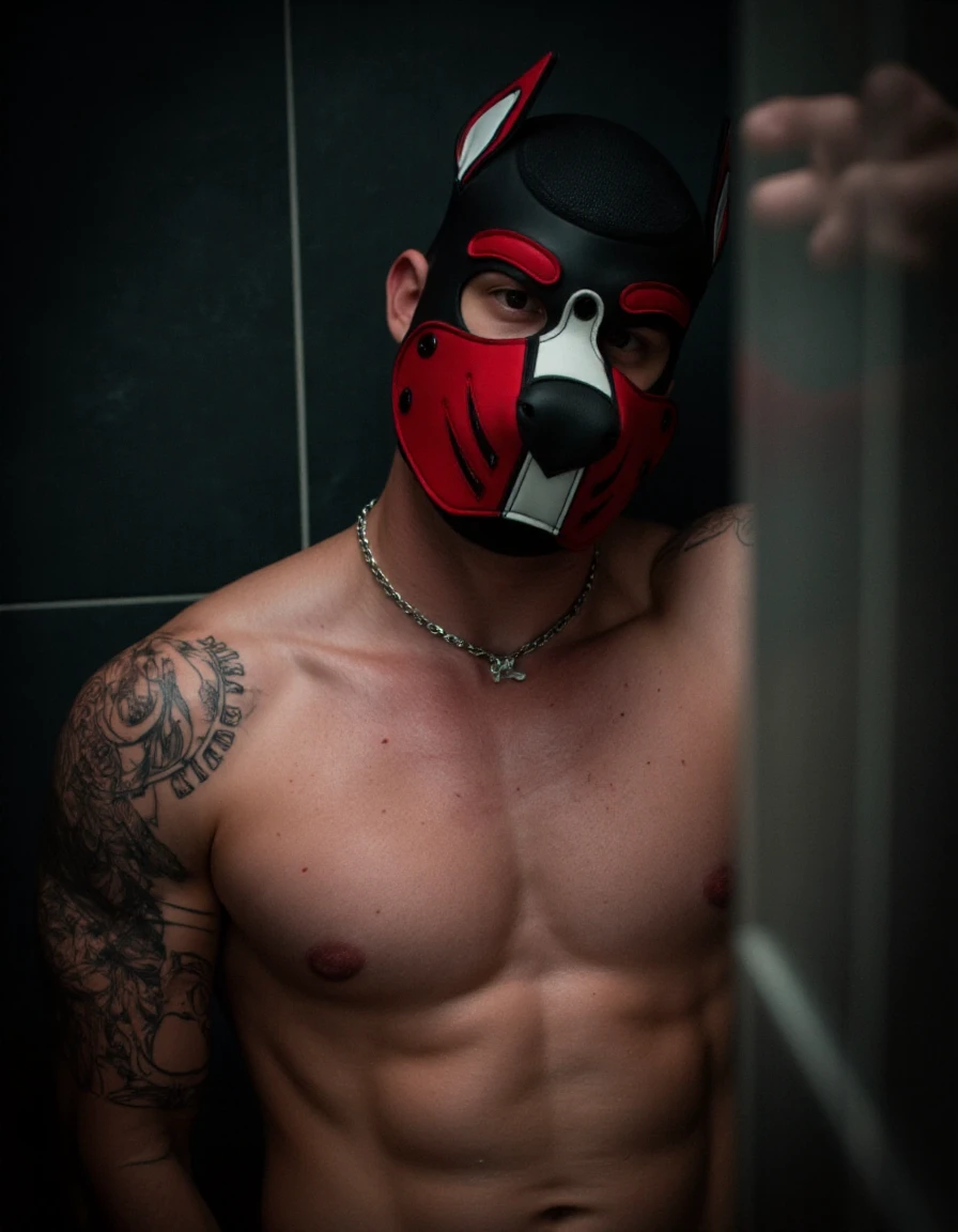 Pup mask with red and black designs and ears. A nude muscular man standing in the shower. The room is dark and Moody. He is wearing a pup mask with bikes and the colors are red and black.