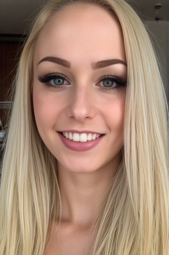 photo of a young woman with blond hair and some freckles, looking with a big smile at viewer.