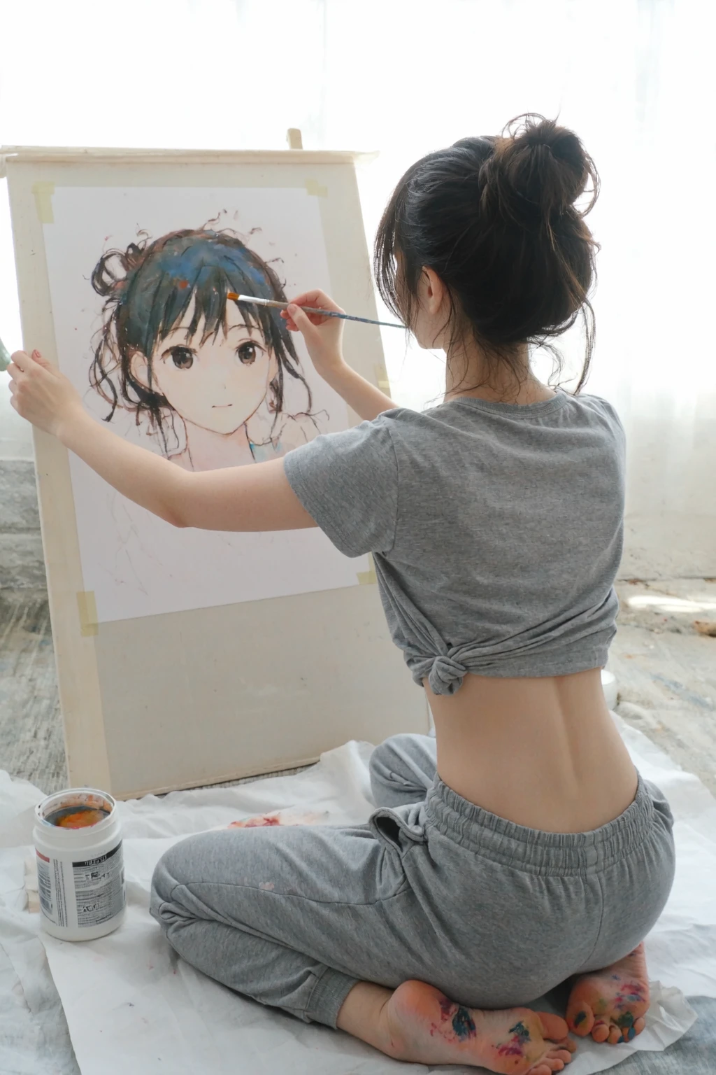 l3n0v0, overexposed indoor scene, young Woman, early 20s, dark hair in messy bun, wearing grey cropped t-shirt exposing midriff, grey sweatpants, barefoot, soles covered with paint, kneeling on white drop cloth, painting anime picture of her portrait, white paint container, viewed from behind while working, natural lighting from unseen source
