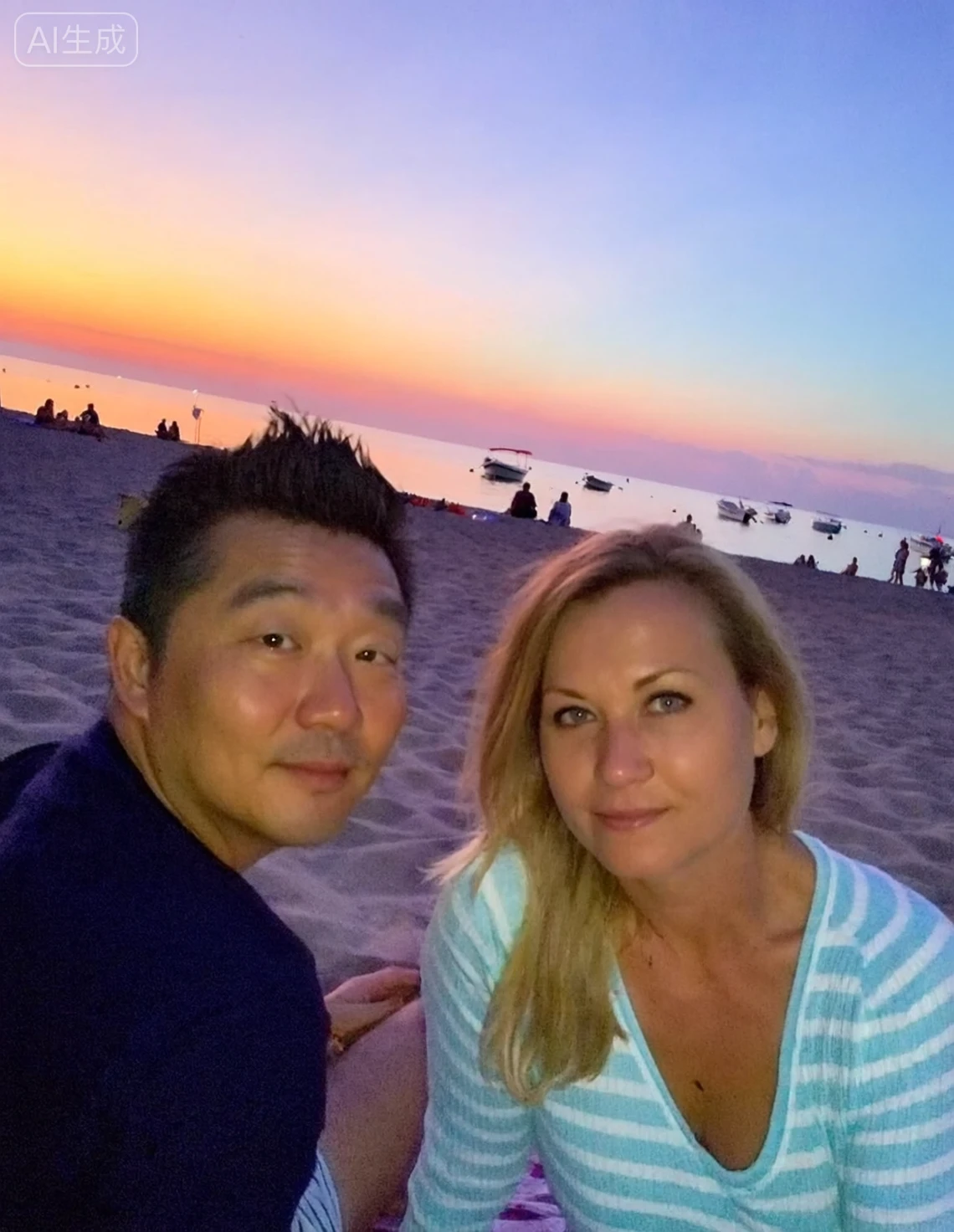 This is a photo of a couple around 40 years old on the beach, with the sunset sky and sea in the background. They are sitting side by side on the sand, facing the camera. The man is on the left side of the frame, Asian, wearing a dark-colored top, with short black hair combed slightly back. The woman is on the right, European, with long blonde hair cascading over her shoulders, wearing a light blue striped top with a slightly low neckline. Both are looking at the camera with relaxed expressions.
The camera is slightly tilted. In the background, the sky displays soft gradient colors, transitioning from orange-red near the horizon to light purple and blue above. The sea is calm, and several small boats can be seen moored on the water in the distance. There are some scattered figures on the beach, some sitting and some standing, but they are far away and their details are unclear.