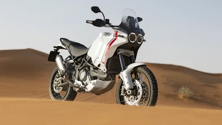 Modern retrostyle arafed adventure motorcycle in the desert standing alone, ducati, retro headlight, skid plate