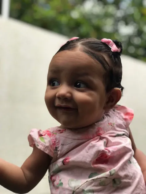 Projete-me um personagem bebê fictício pequeno , fofo , fofo e charmoso , com sorriso fofo , cabelos ondulados e olhos relaxantes. personagem deve ter uma aparência suave e calmante.