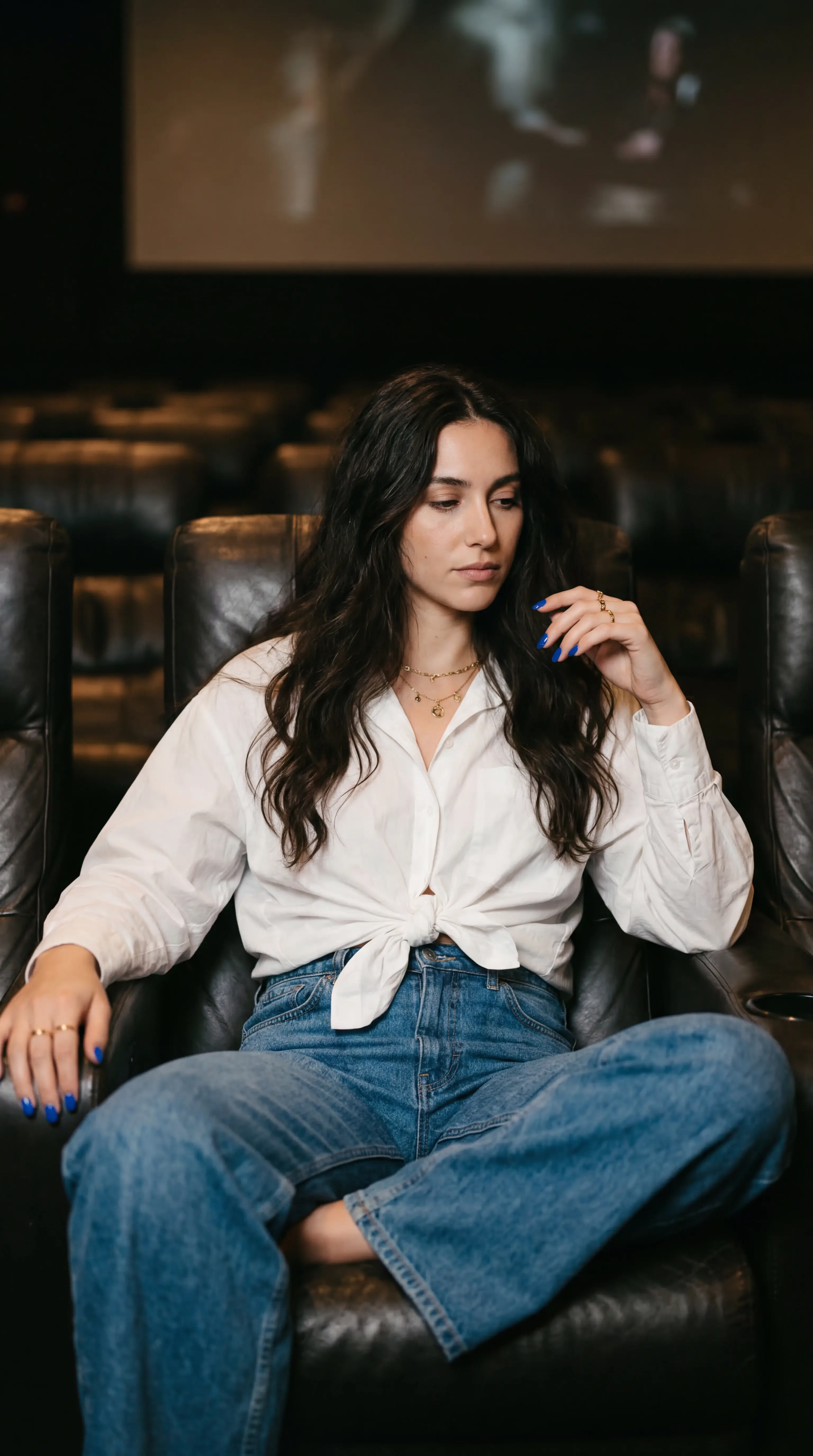 Best Grok Imagine Prompt for Fashion Portrait โ Woman Relaxing in Cinema Seat With Screen Glow