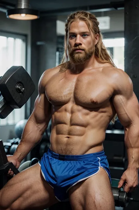 Man in the gym wirh big muscles, blonde hair like vikings, blue eyes and beard looking like thor