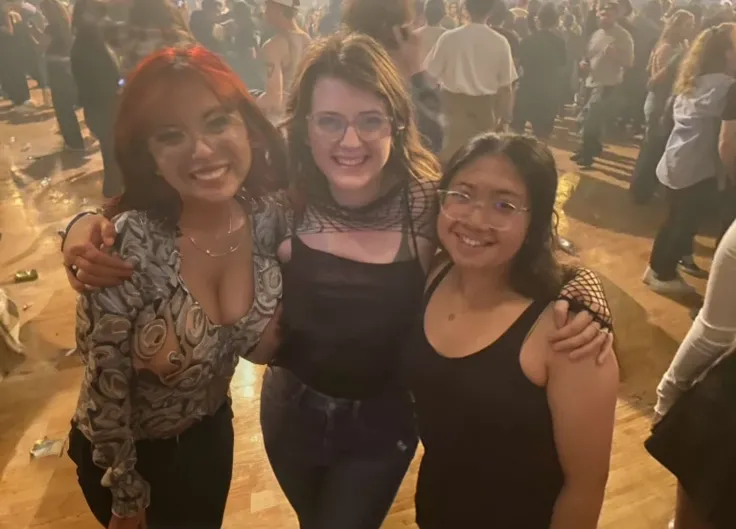 three women standing next to each other in a room full of people, non blurry, with tiny people, concert photo, not blurry, photo taken in 2 0 2 0, very grainy, very very low quality picture, profile pic, profile picture, very very low quality, by Bernie D’...