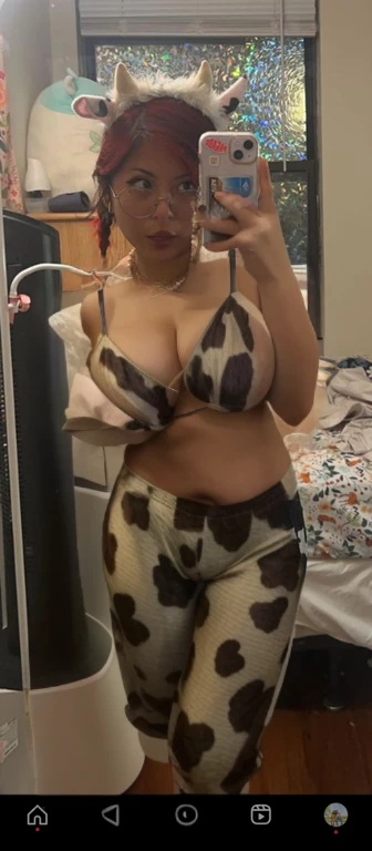 woman in cow print pants taking a selfie in a mirror, campy. cow costume with udders, 2 4 year old female model, coirl, 2 2 years old, 2 3 years old, wearing two - piece swimsuit, 21 years old, she has a jiggly fat round belly, 3 0 years old woman, 30 year...