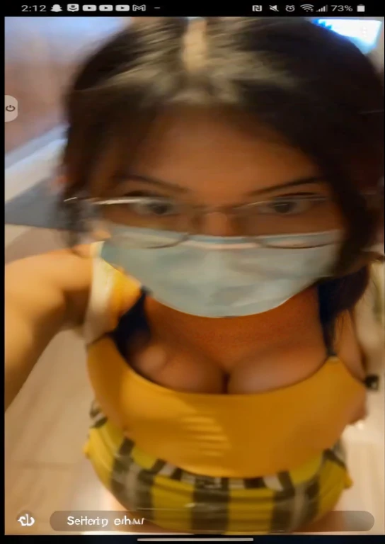 arafed woman wearing a mask and glasses brushing her teeth, snapchat story screenshot, surgical mask covering mouth, mask off, the mask covers her entire face, wearing facemask and sunglasses, she is facing the camera, low quality video, wearing transparen...