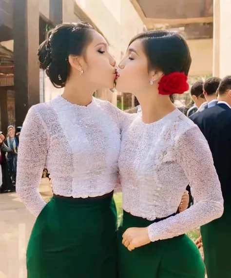 2 girls who gets married and stands in front of many people, kissing