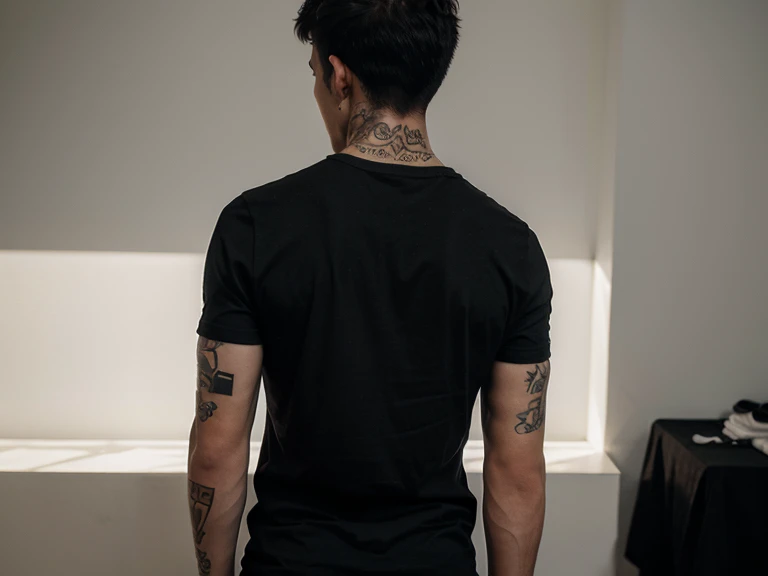 man with tattoo on his back wearing a simple basic black t-shirt with no print and full body