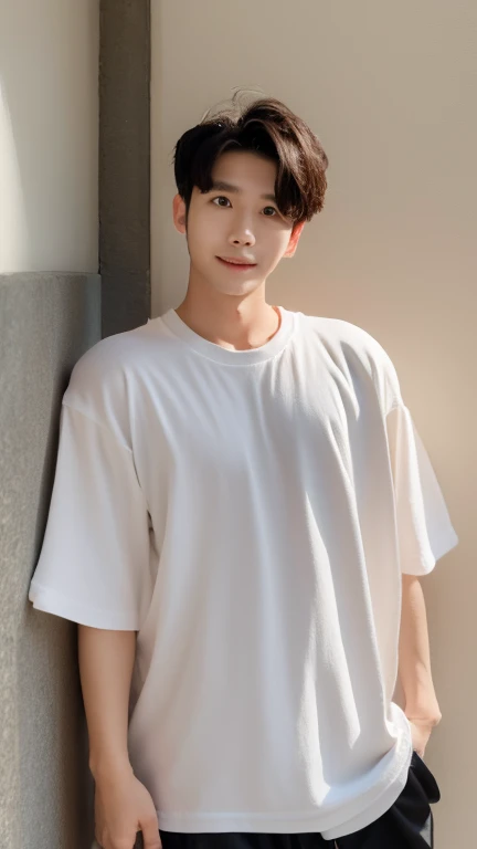 A white Thai man wearing an oversized black T-shirt with no pattern leans against a wall.