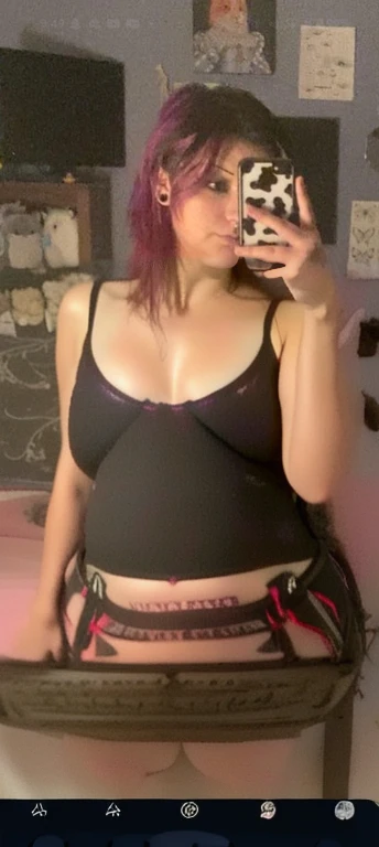 arafed woman taking a selfie in a mirror with a cell phone, wearing crop top, she has a jiggly fat round belly, she is wearing a black crop top, wearing a cropped black tank top, wearing a black cropped tank top, fit pic, half body cropping, 2 2 years old,...