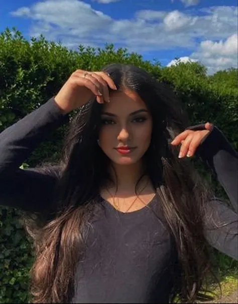 femme arafée aux cheveux longs debout devant des buissons, female avec de longs cheveux noirs, jeune femme aux longs cheveux noirs, violette myers, aux cheveux noirs et raides, elle a environ 1 6 ans, photo d&#39;un modèle, demi rose, avec de longs cheveux...