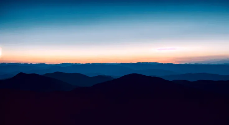 A beam of red light Between the skyline and the even mountain range