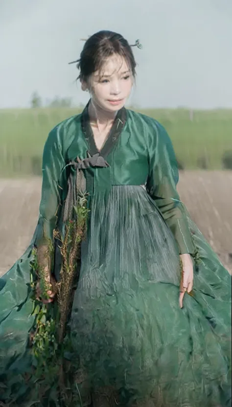 a woman in a green dress is standing in the field