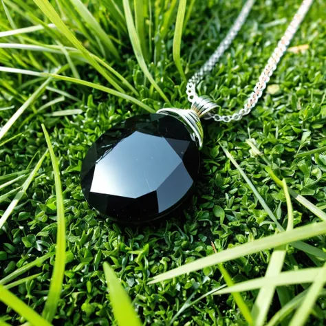 black stone pendant lying in the grass